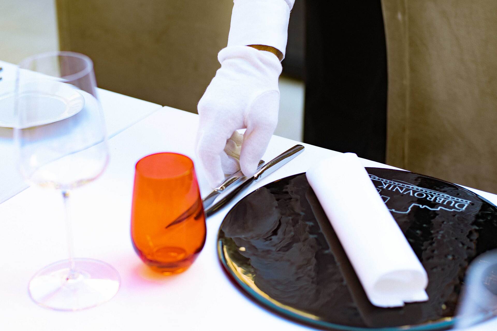 Restaurant Dubrovnik - Old Town -waiter getting table ready for guests, Restaurant Dubrovnik plate with logo on the bottom side