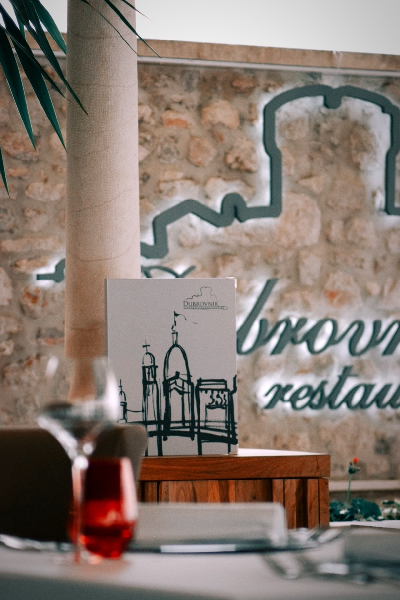 Restaurant Dubrovnik menu with logo and logo on the wall behind the menu - Restoran Dubrovnik u centru same jezgre, meni i logo od restorana u pozadini na zidu
